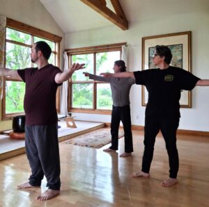 Participants practising qigong together in a sunlit room